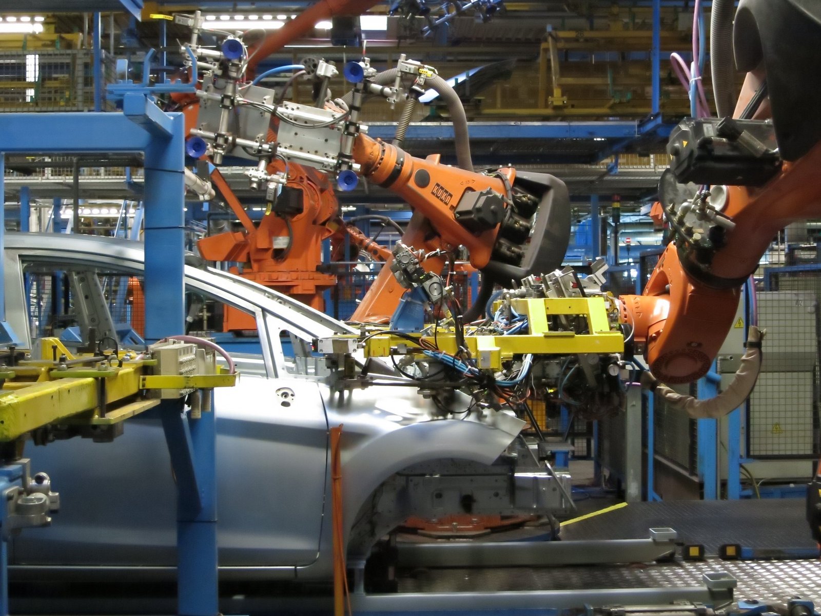 Area produttiva automotive con robot industriali in attività