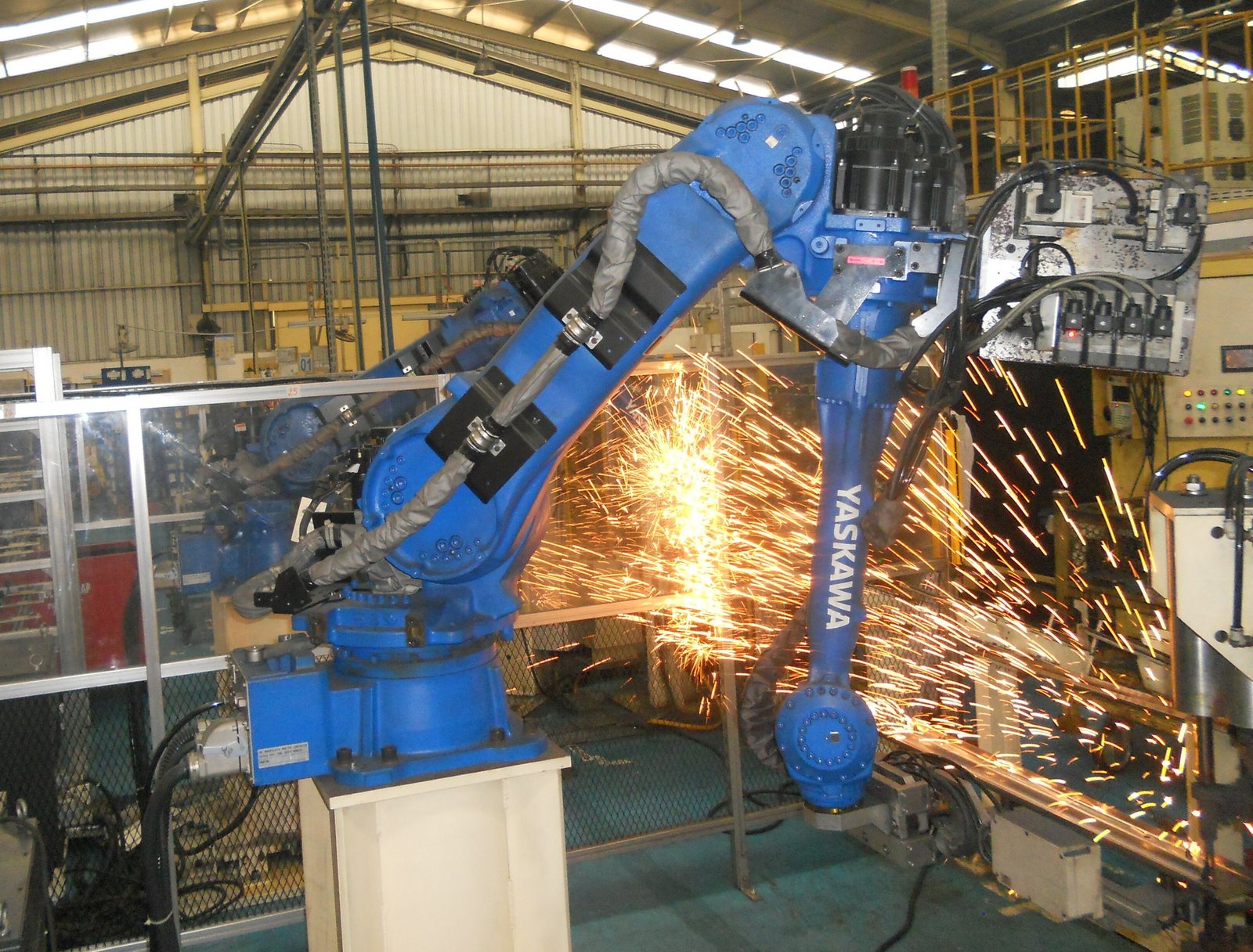 Robot di saldatura in area produttiva con attrezzaggi industriali