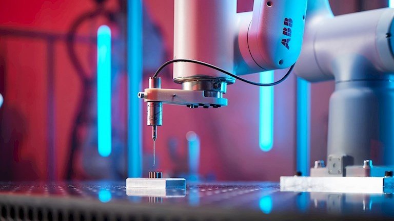 Robot ABB di precisione al lavoro su una postazione automatizzata con illuminazione tecnica