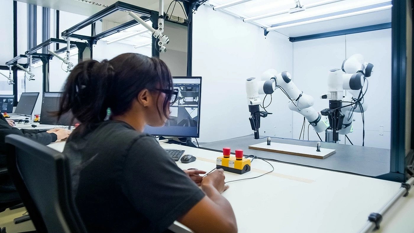 Laboratorio di robotica con ricercatrice e bracci collaborativi
