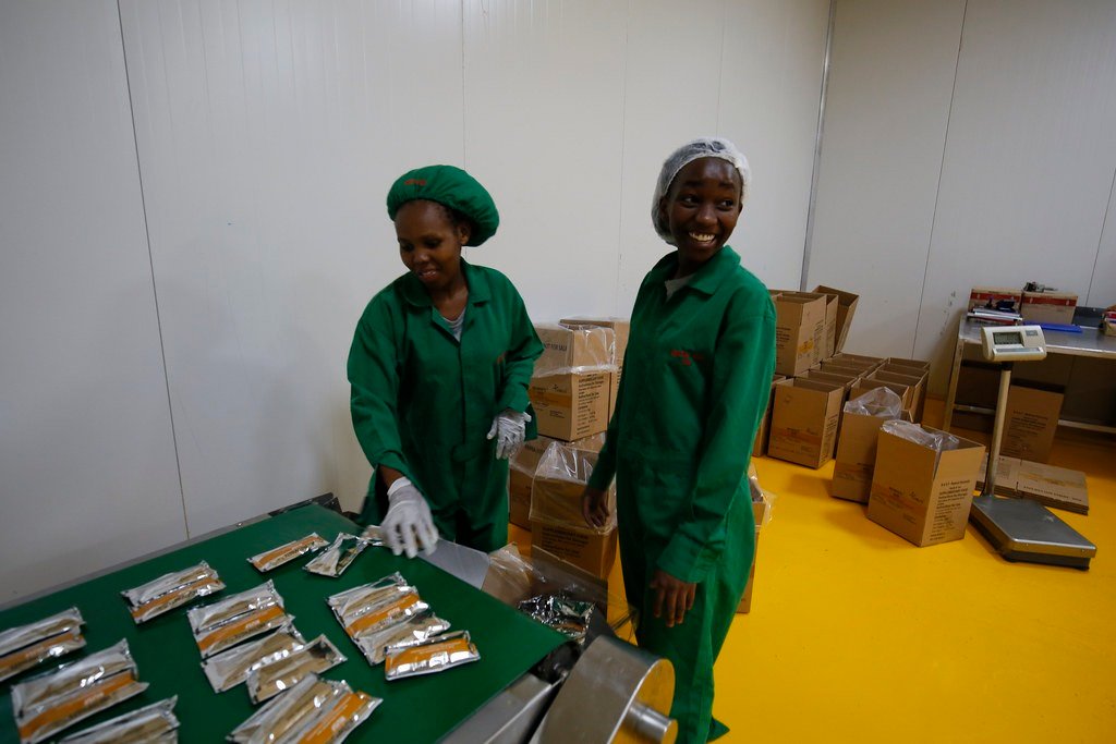 Linea di confezionamento alimentare con operatori e prodotti su conveyor