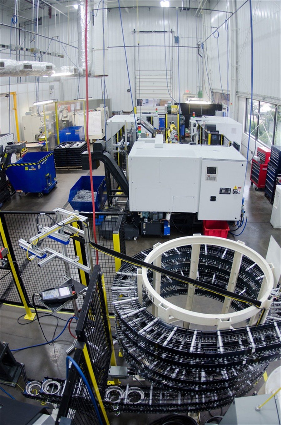 Area manifatturiera con macchina CNC, nastri e recinzioni di sicurezza in ottica OT safety