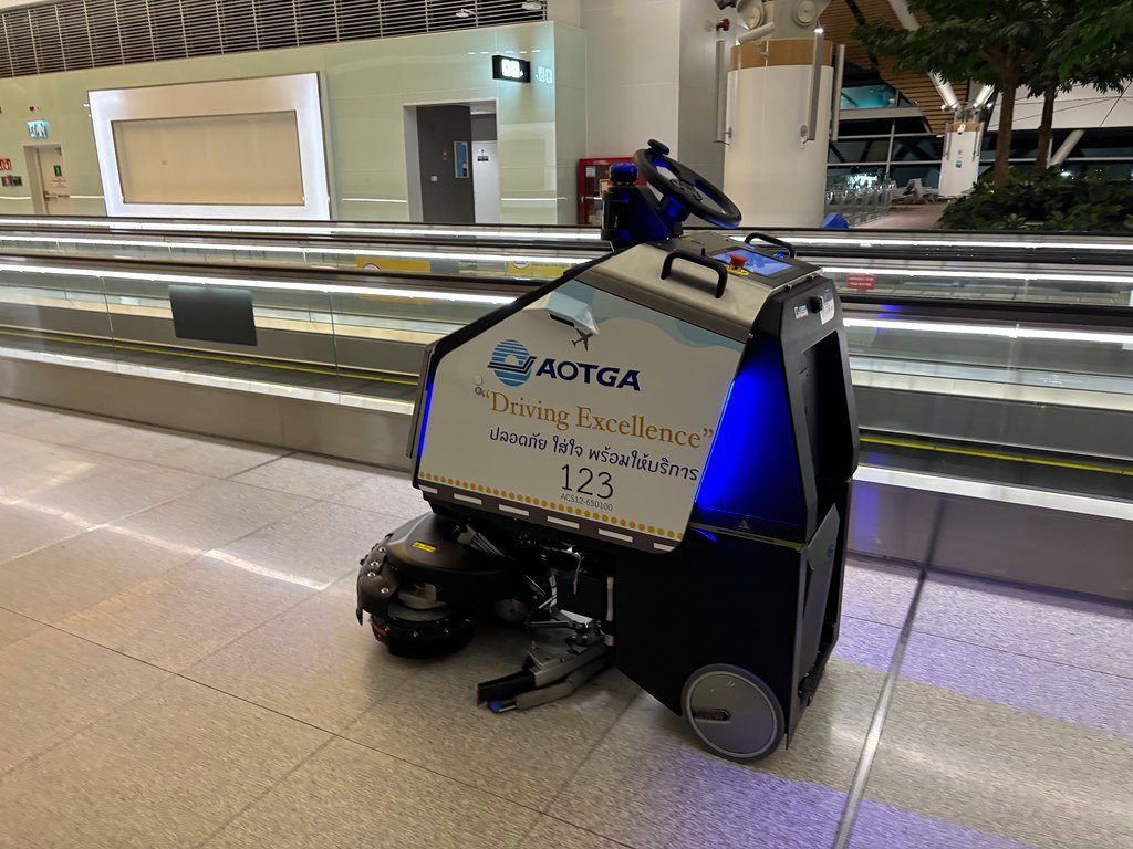 Robot scrubber autonomo in supermercato durante pulizia dei corridoi commerciali
