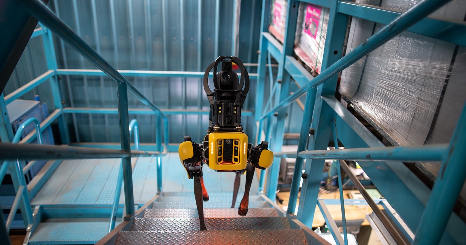 Robot quadrupede Spot scende scale metalliche in impianto industriale