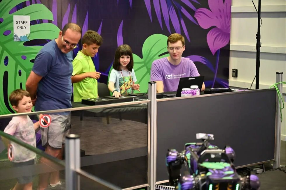 Bambini e staff guidano un robot quadrupede durante un'esperienza pubblica