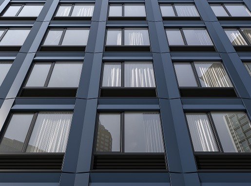 Dettaglio di facciata modulare con pannelli prefabbricati blu e finestre allineate