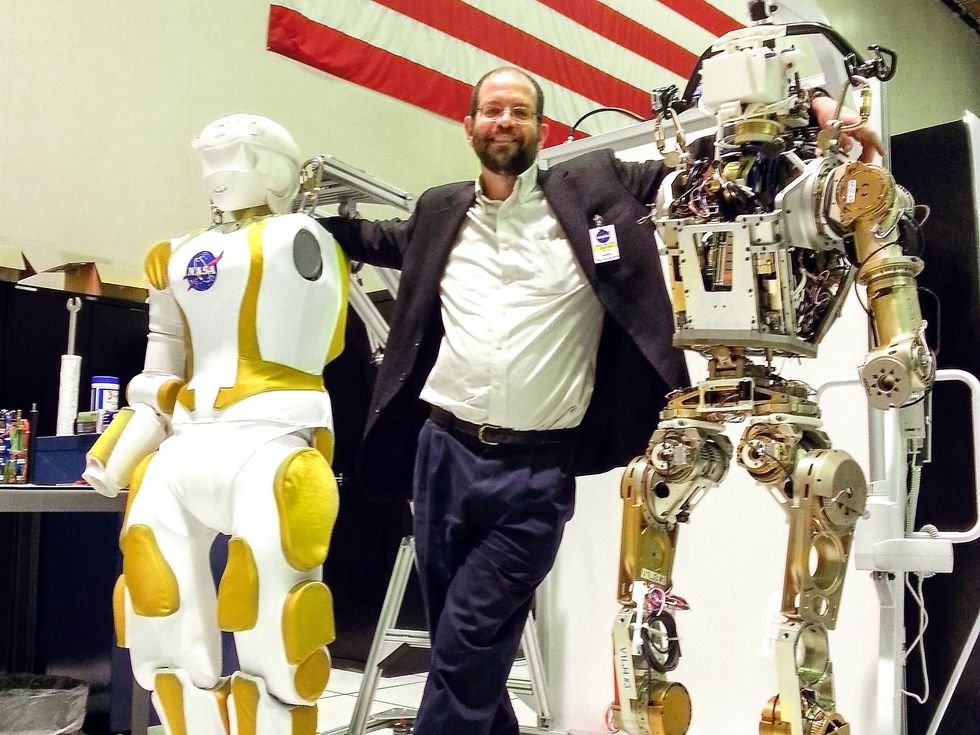 Gill Pratt con due robot umanoidi durante una dimostrazione di ricerca