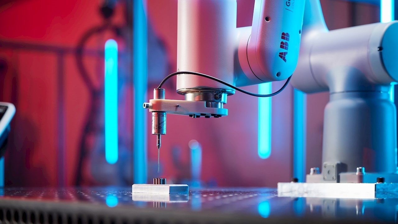 Braccio robotico ABB impegnato in lavorazione di precisione su componente metallico