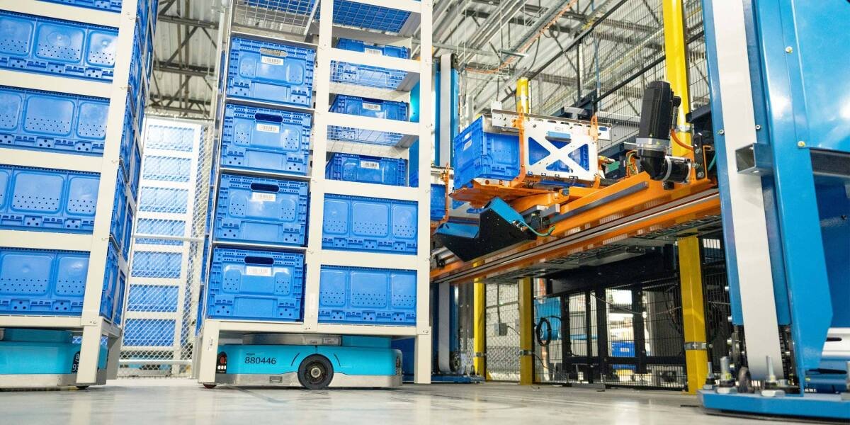Sistema robotico e AGV in un fulfillment center Amazon con scaffalature e contenitori blu
