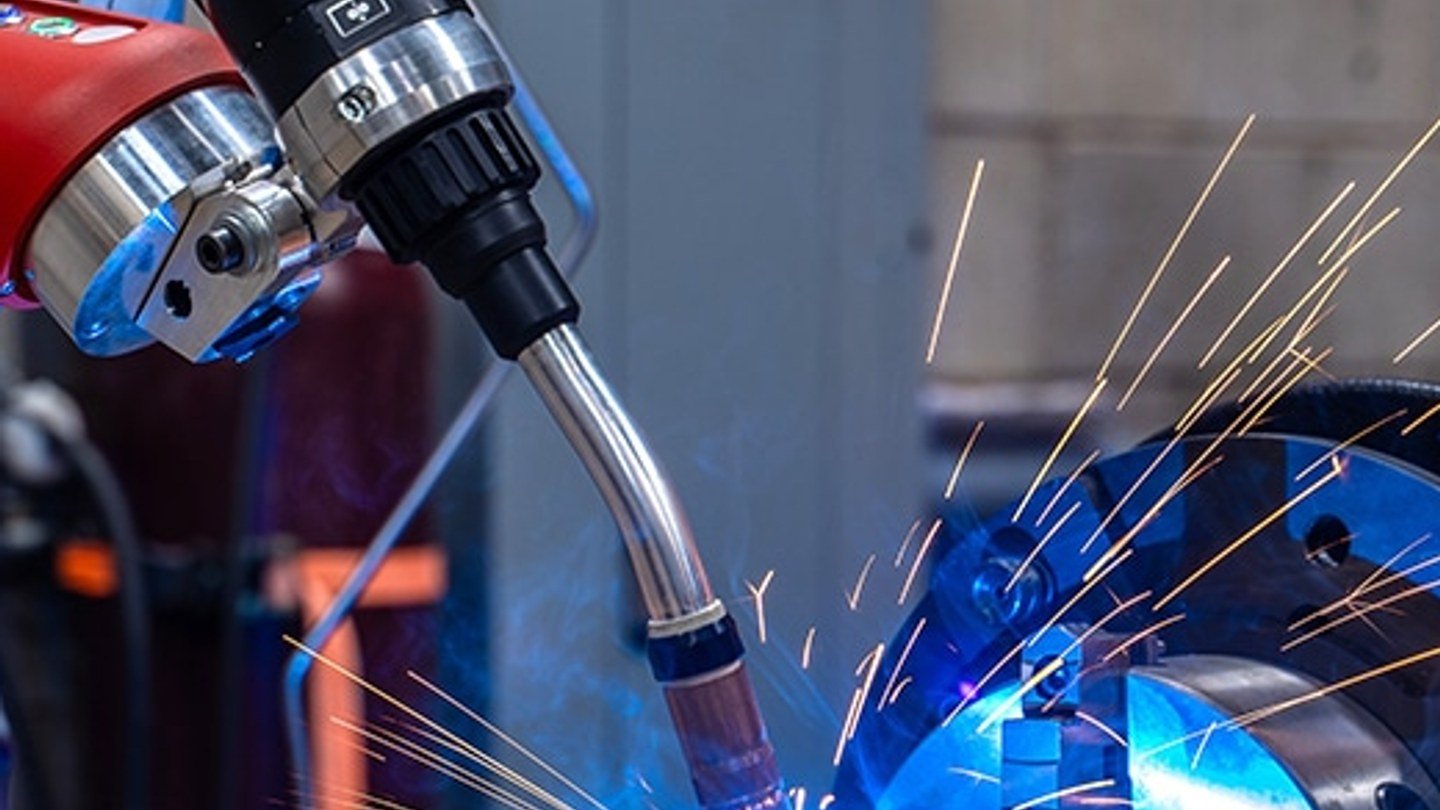 Torcia di saldatura robotica all'opera su un pezzo montato su posizionatore