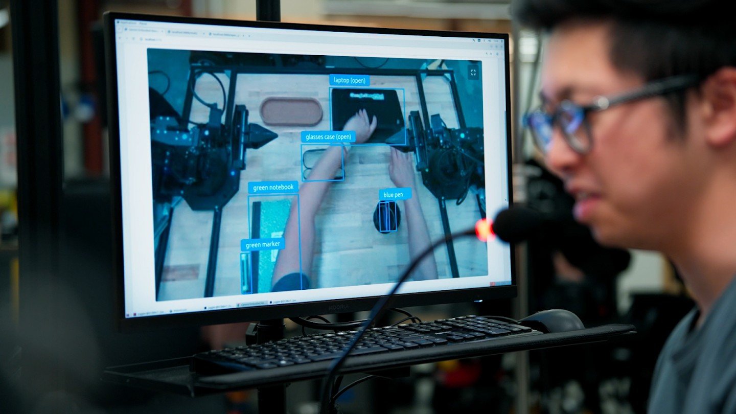 Ricercatore osserva un monitor con object detection e classificazione di oggetti per la robotica