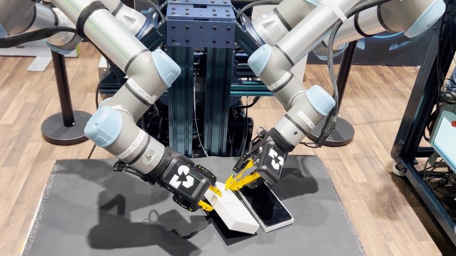 Due cobot Universal Robots eseguono un task di manipolazione fine su smartphone