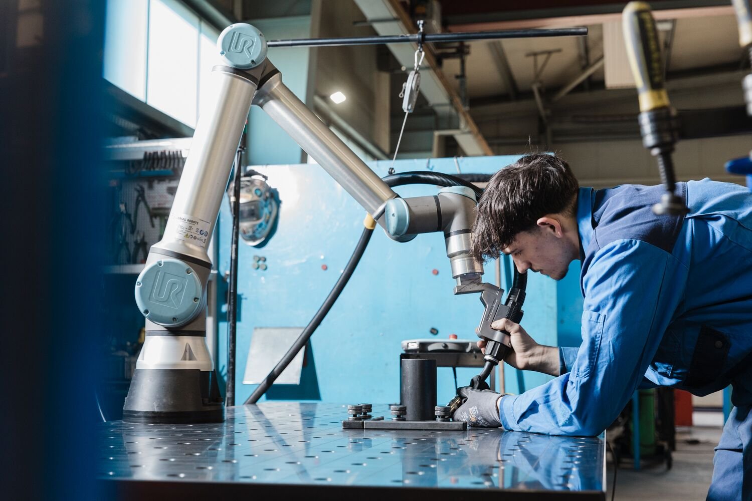 Operatore in officina accanto a un cobot Universal Robots