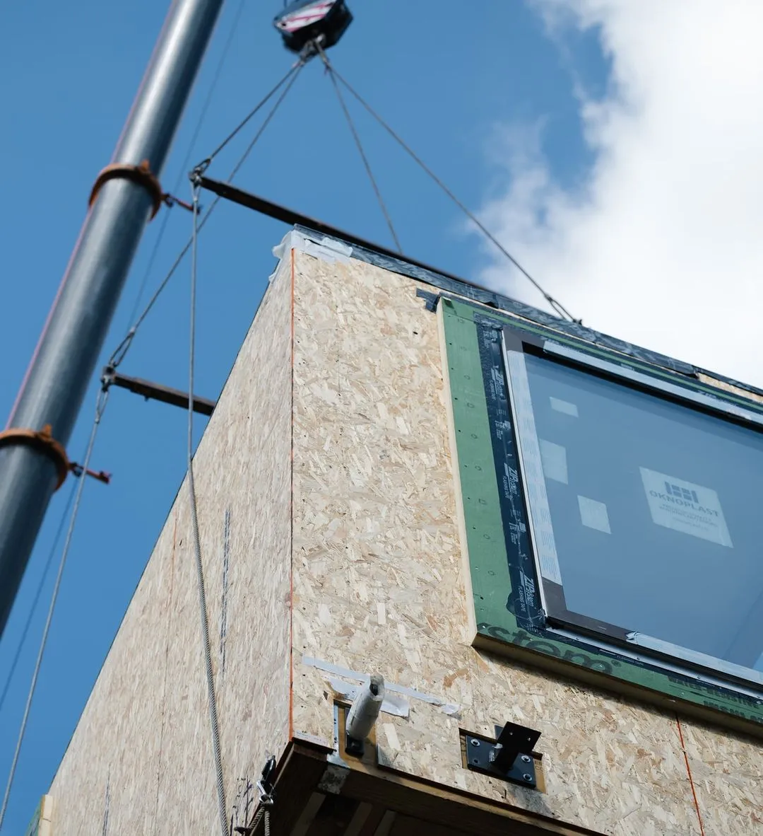 Pannello prefabbricato sollevato in cantiere durante un progetto di edilizia modulare