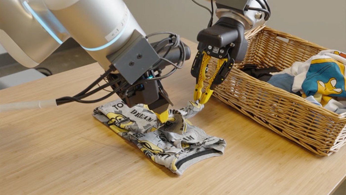 Bracci robotici che piegano una maglietta per addestrare modelli di physical AI