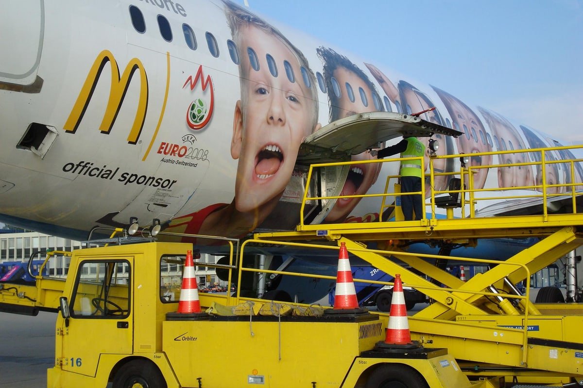 Operazioni di ground handling con mezzi e personale vicino a un aeromobile