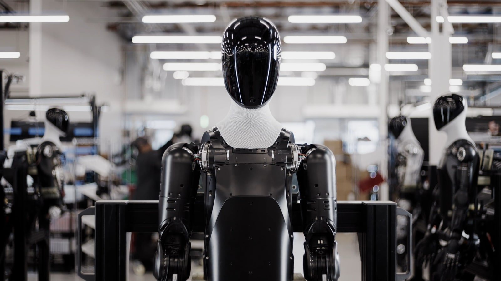 Fotogramma ufficiale Figure AI con Figure 03 su una linea BotQ, circondato da altri umanoidi in produzione