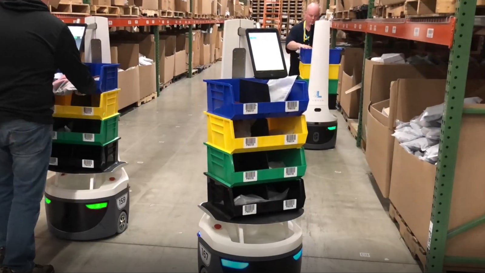 Robot mobili Locus in corsia di magazzino con contenitori per fulfillment