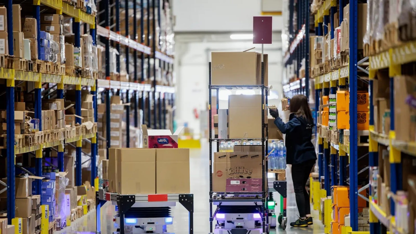 Corsia di magazzino con scaffali e attività di picking robotico