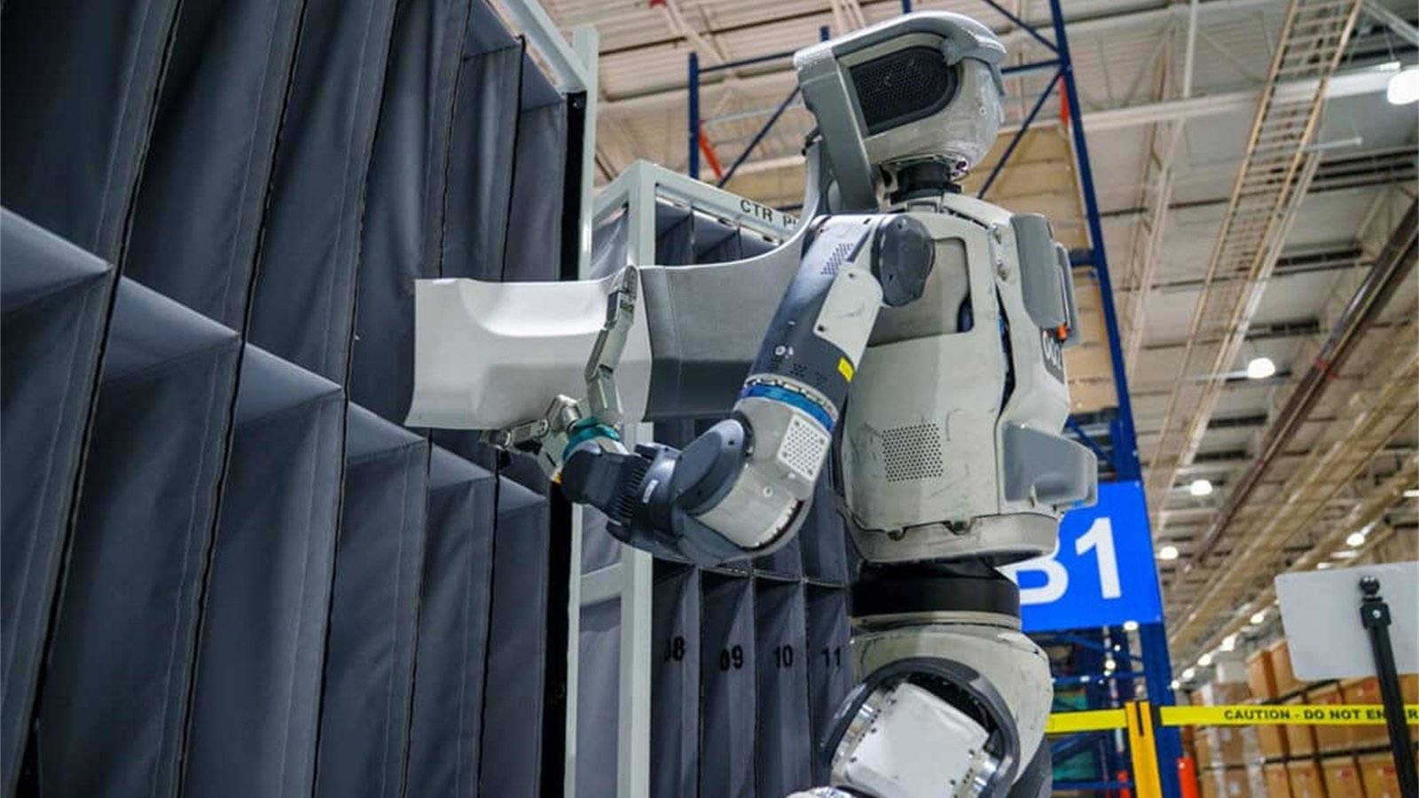 Atlas lavora vicino a un contenitore industriale durante un test di manipolazione