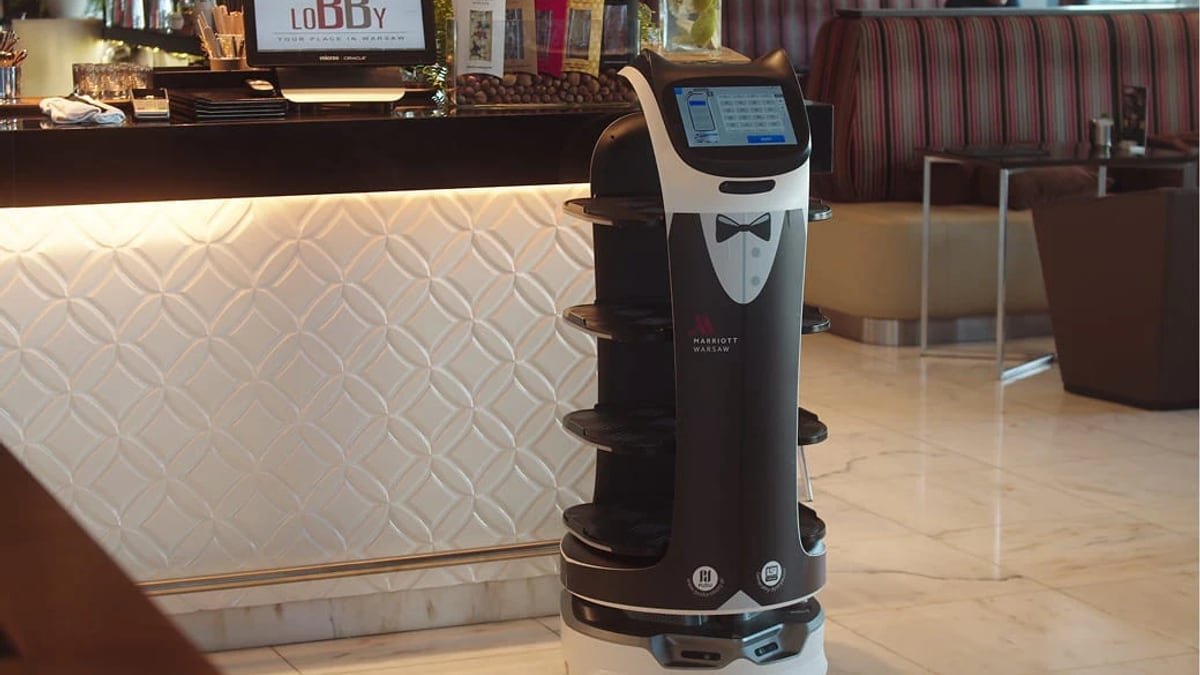 Robot di servizio in ambiente hospitality davanti a un banco di accoglienza