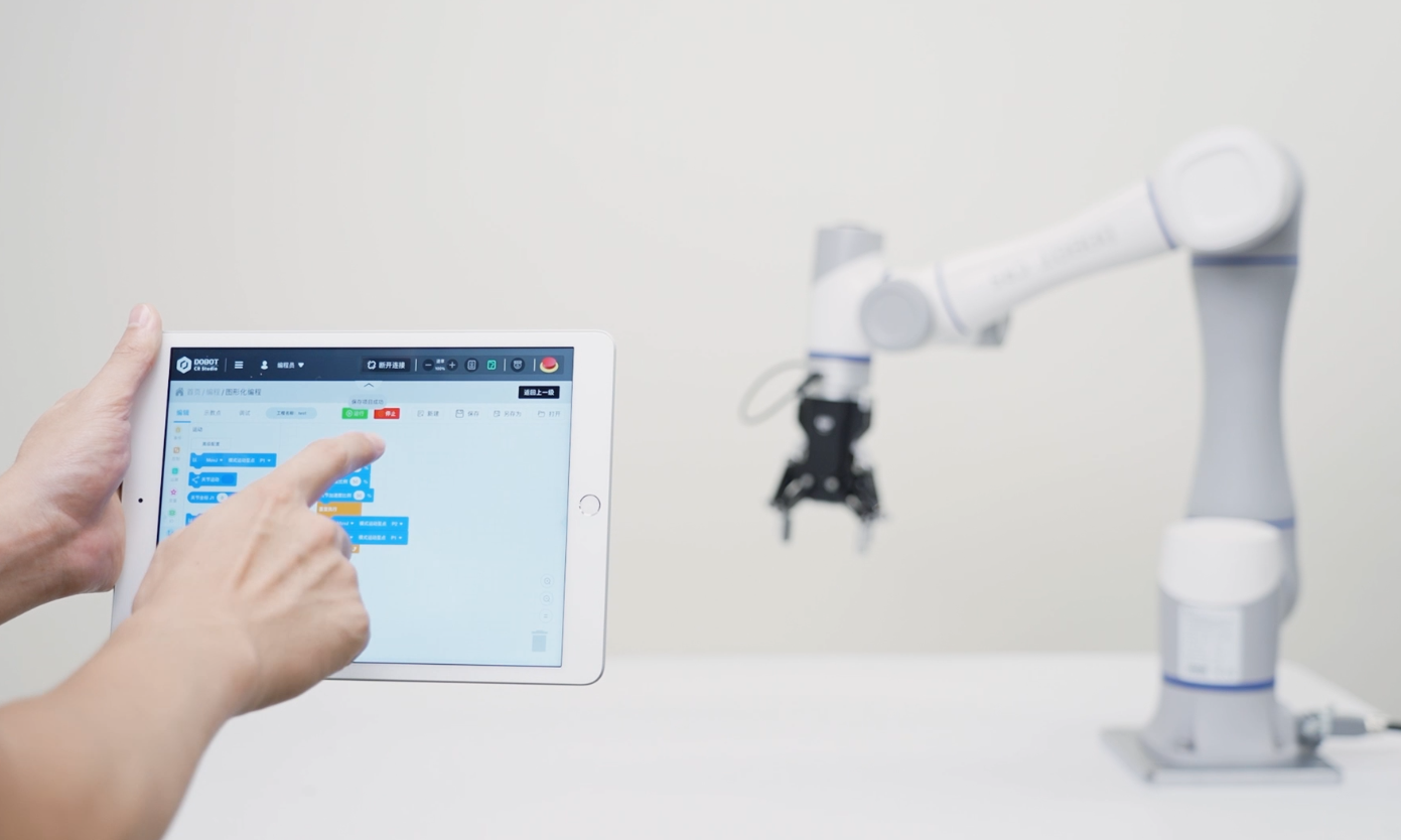 Operatore che programma un cobot Dobot da tablet per applicazioni di assemblaggio e test