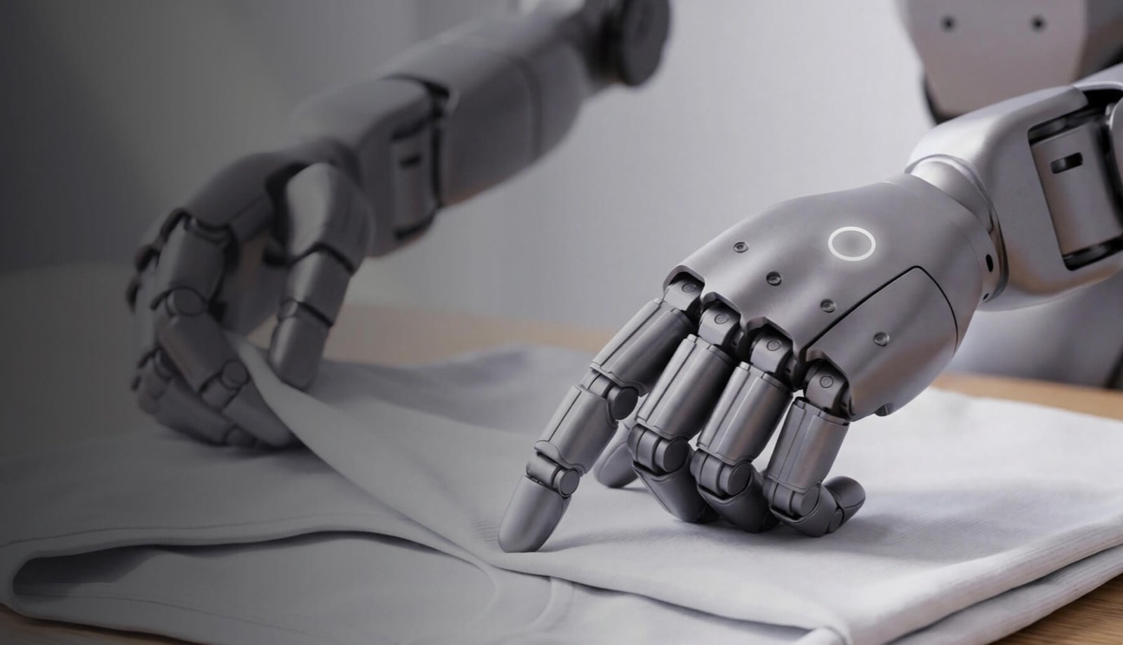 Dettaglio delle mani robotiche Unitree H2 su un tessuto durante una dimostrazione di manipolazione