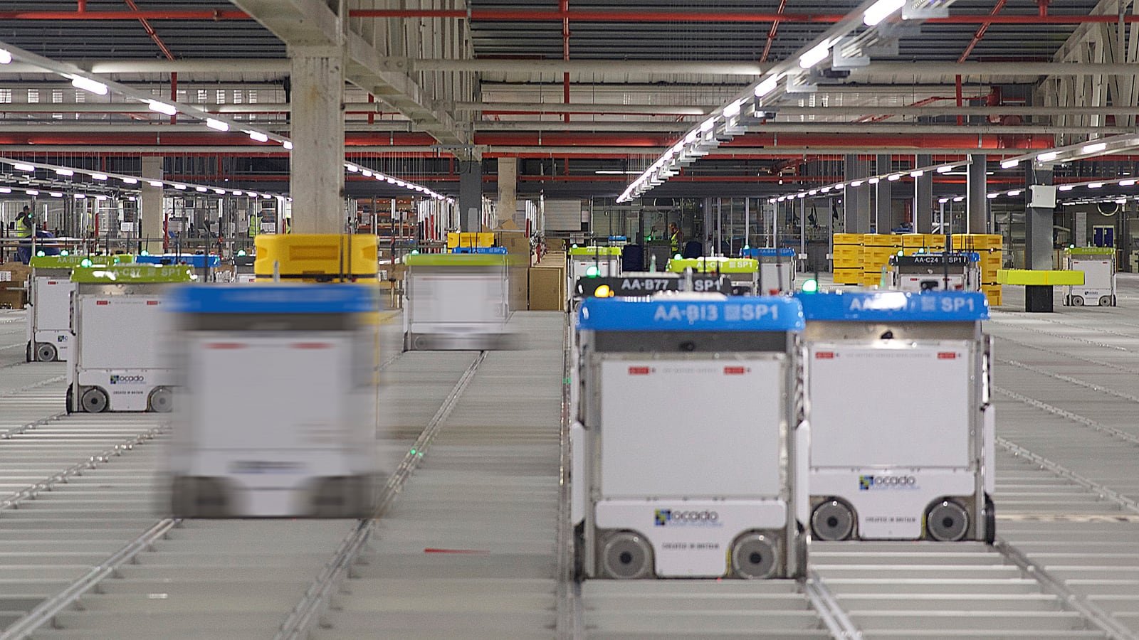 Robot mobili autonomi che si muovono in un magazzino e-commerce con corsie e carrelli